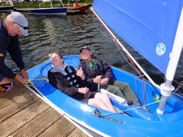 Two people in a blue sailing boat