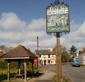 Bus shelter left, Rowledge village sign, pub in background