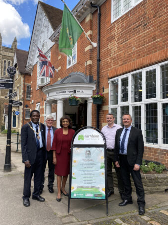 Five people standing next to an advertising A-frame.