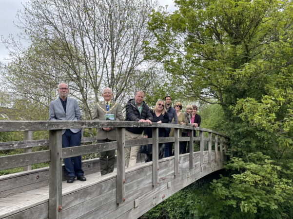 Group of people standing on a wooden bridge
