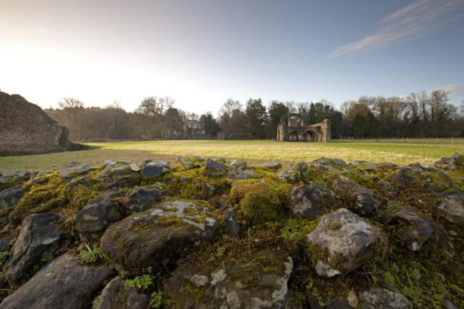 Abbey ruins on green open space. Open countryside and blue sky