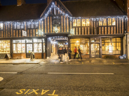 An old building in a town centre decorated with white Christmas lights