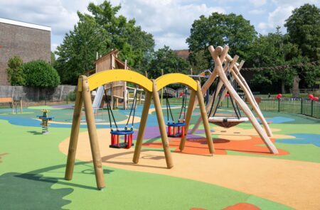 Toddler swings and a nest swing in a children's playground.