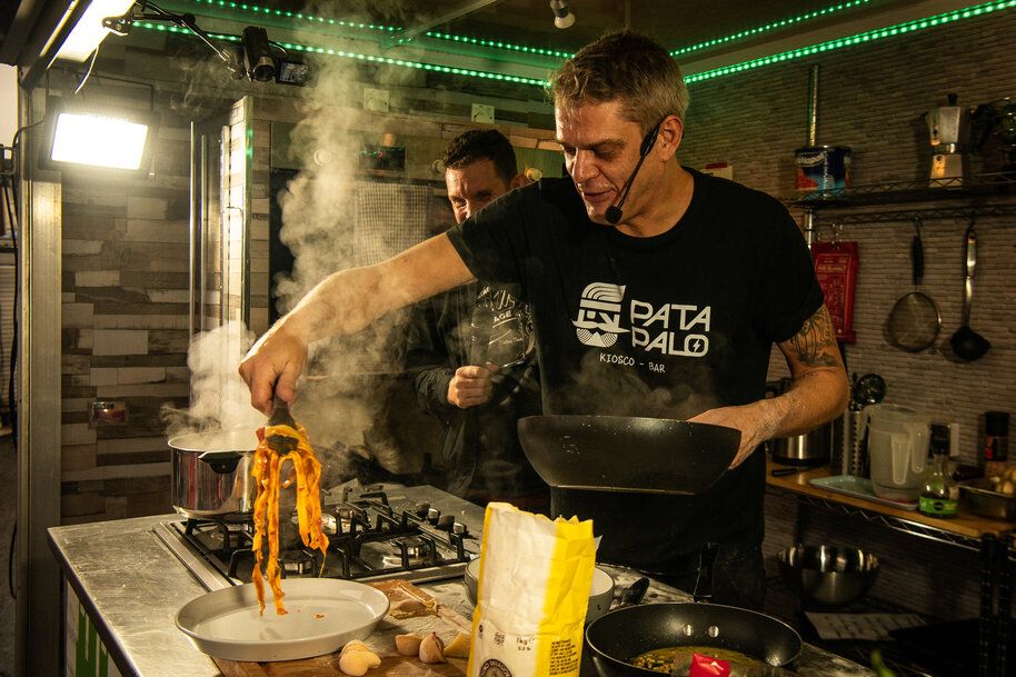 Chef cooking noodles in a kitchen.